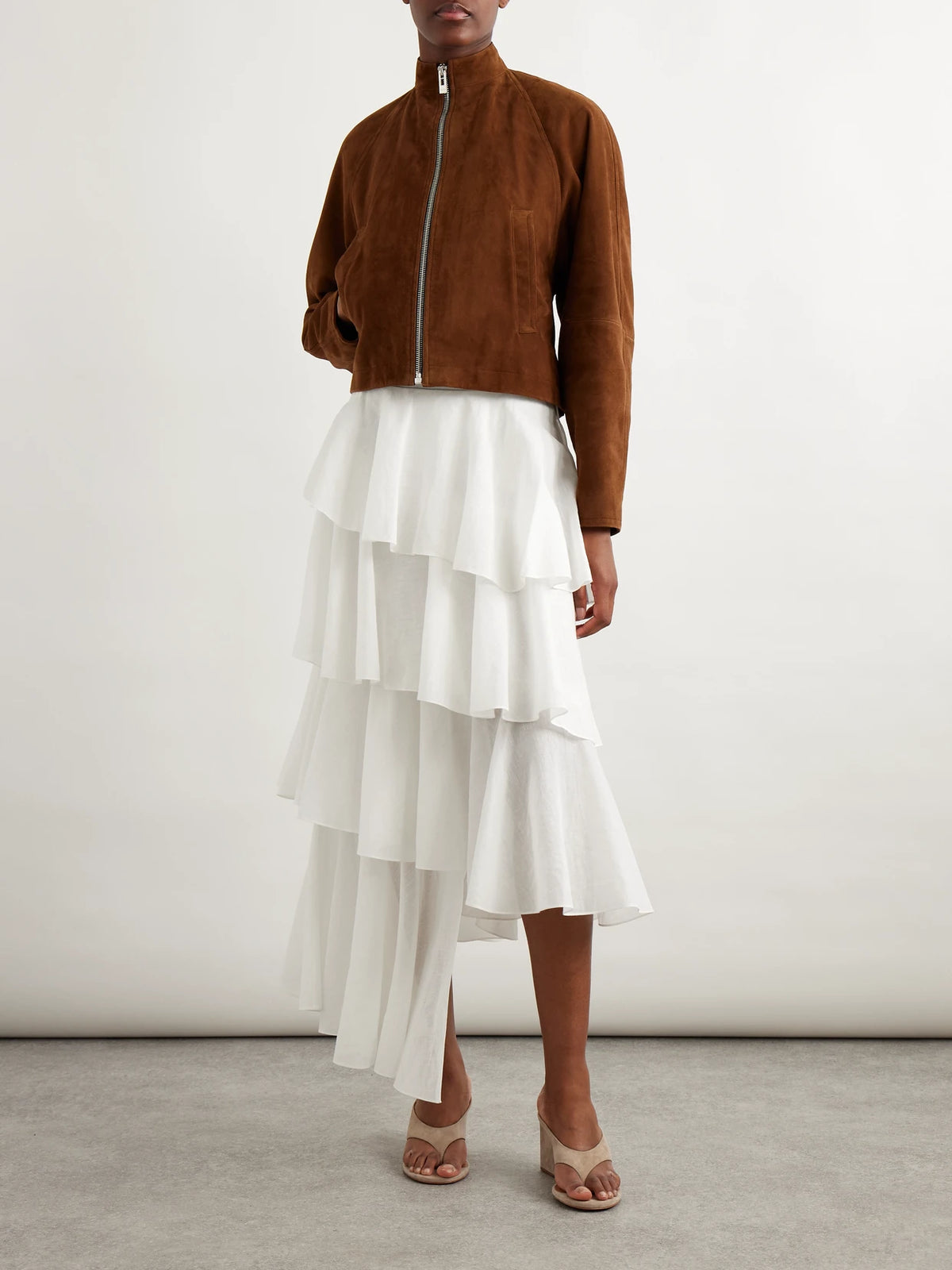 Image of a model wearing Skirts. Product name - Tiered Asymmetric Cotton Midi Skirt in White colour by brand - Alaïa