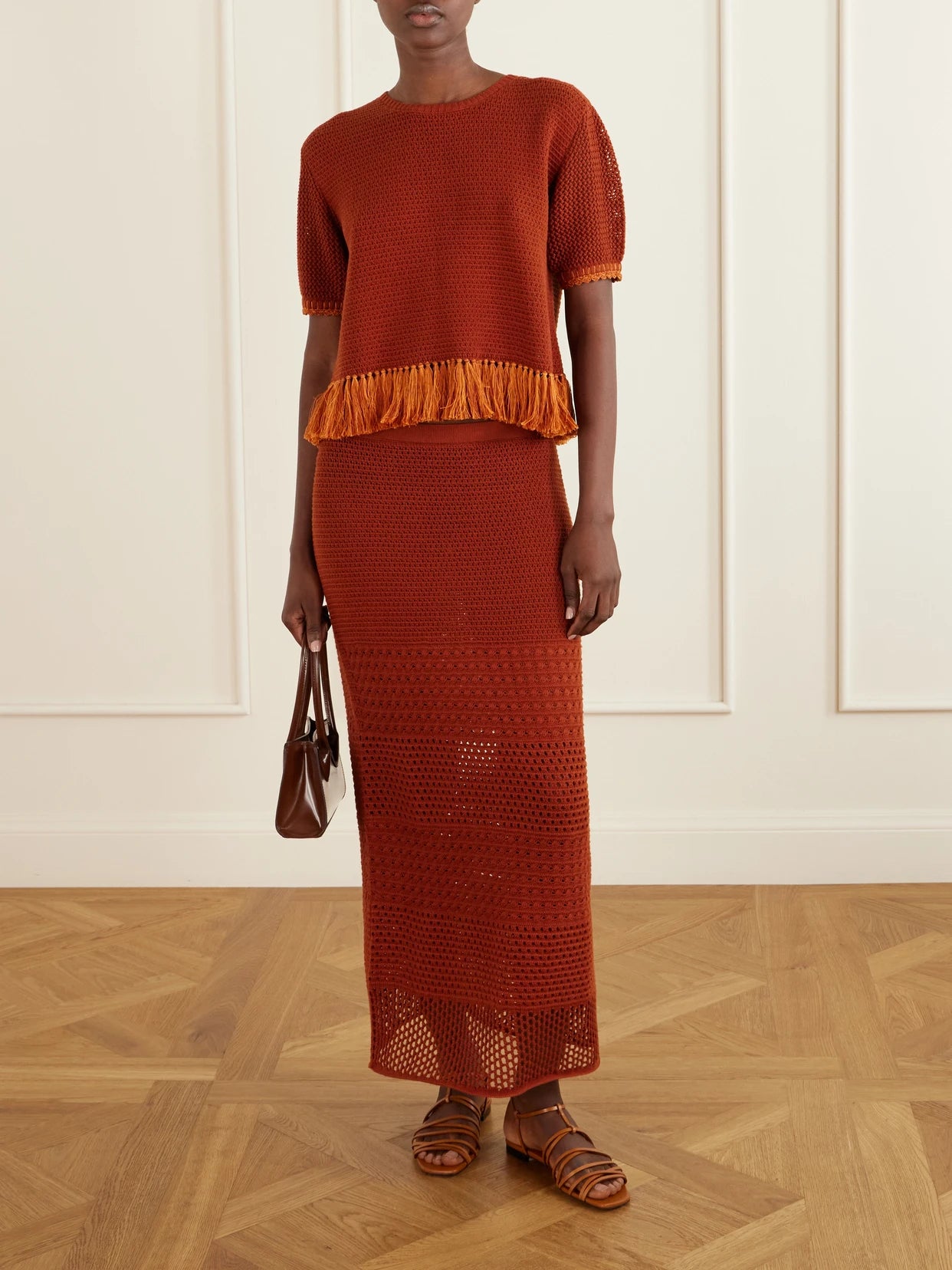 Image of a model wearing Skirts. Product name - Amada Crocheted Cotton Maxi Skirt in Brick colour by brand - ESCVDO