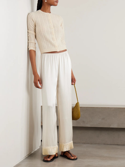 Image of a model wearing Outerwear. Product name - Danae Cropped Cable-knit Cashmere Cardigan in Cream colour by brand - DÔEN