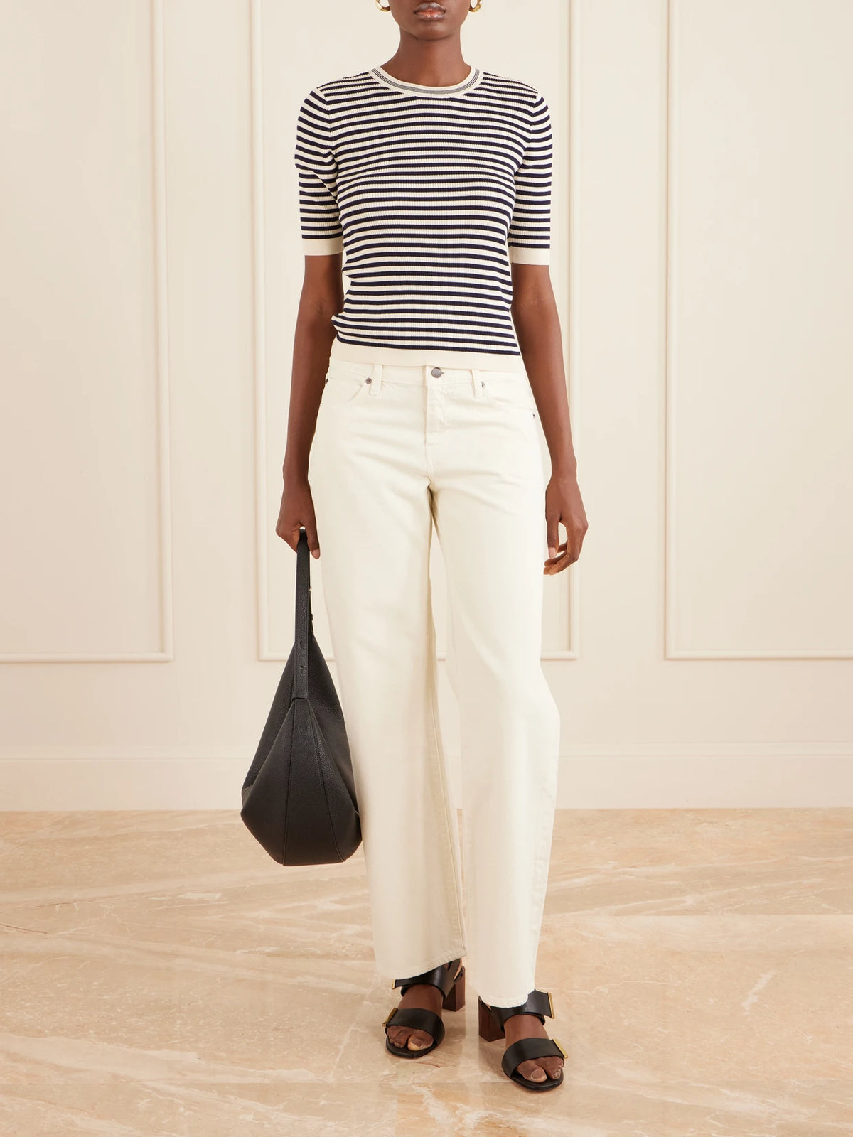Image of a model wearing Tops. Product name - Striped Cotton-blend T-shirt in Black colour by brand - FRAME