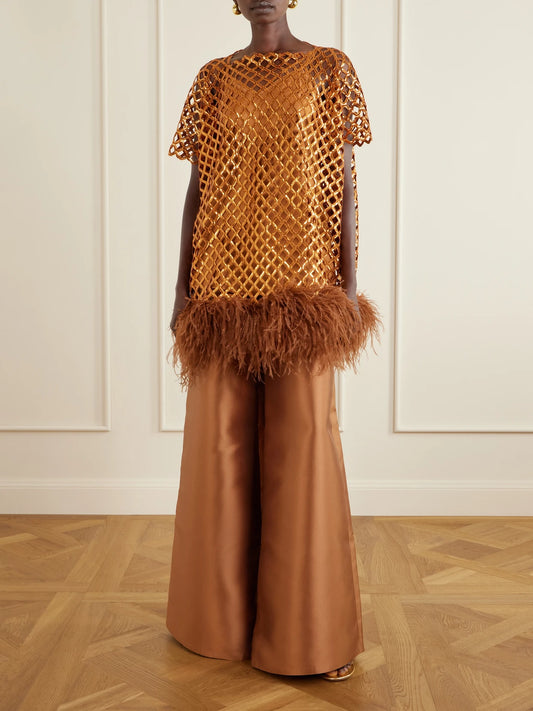 Image of a model wearing Tops. Product name - Feather-trimmed Sequined Blouse in Gold colour by brand - Dima Ayad