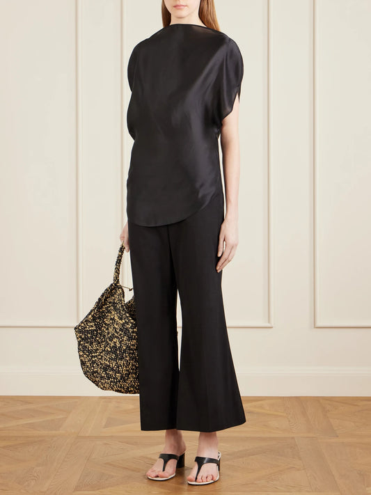 Image of a model wearing Tops. Product name - Poppi Satin Blouse in Black colour by brand - KHAITE