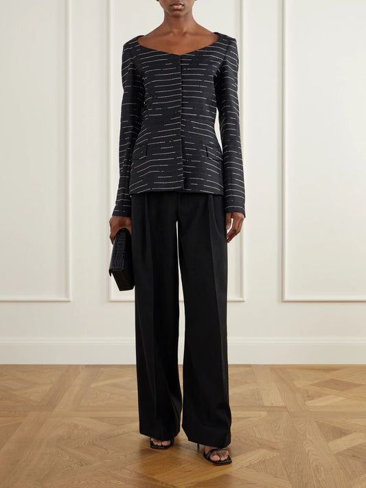 Image of a model wearing Pants. Product name - Mika Pleated Wool Straight-leg Pants in Black colour by brand - LIBEROWE