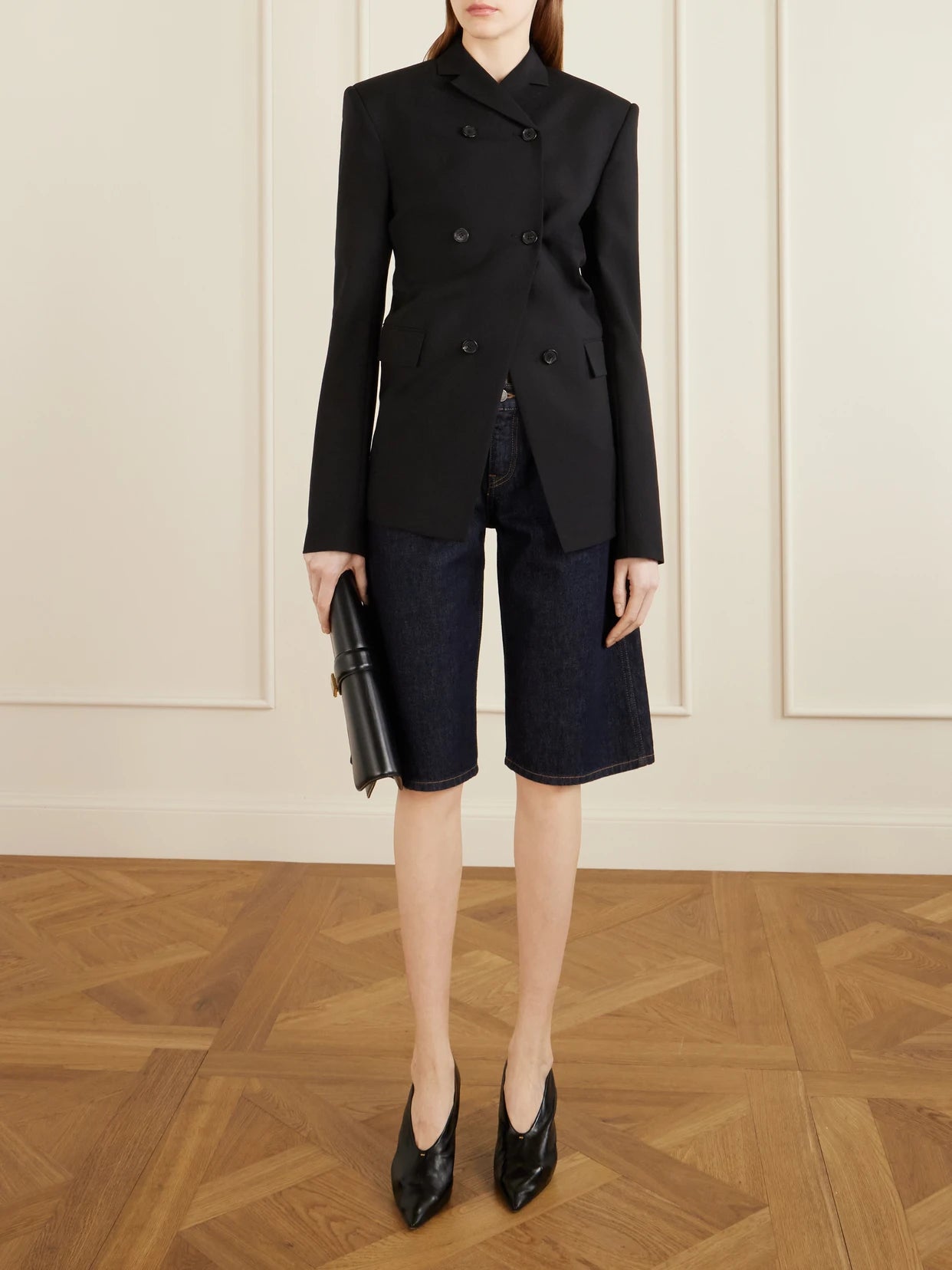 Image of a model wearing Shorts. Product name - Kinga Mid-rise Straight-leg Shorts in Dark denim colour by brand - KHAITE