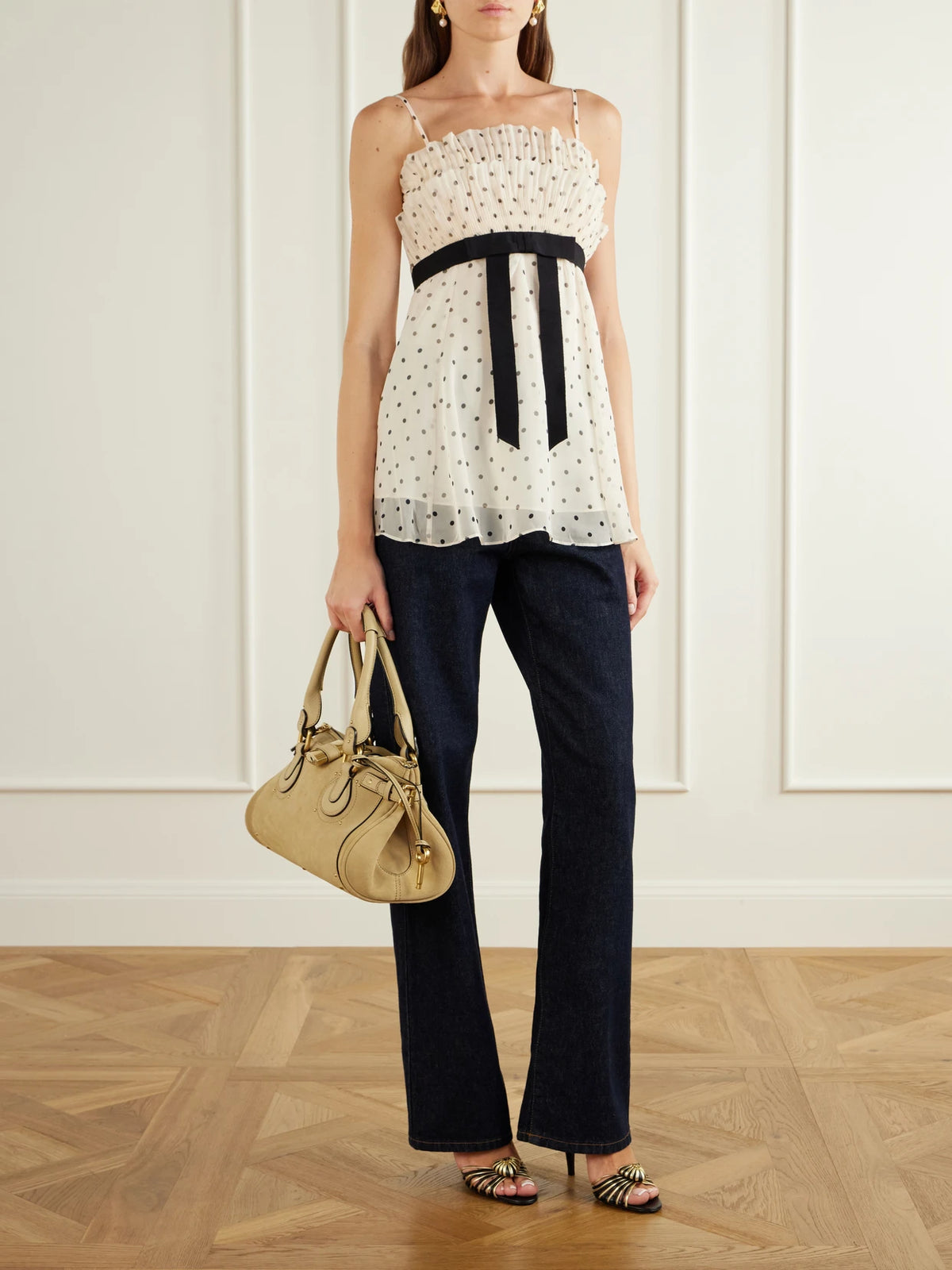 Image of a model wearing Tops. Product name - Pleated Bow-detailed Polka-dot Chiffon Top in Cream colour by brand - Zimmermann