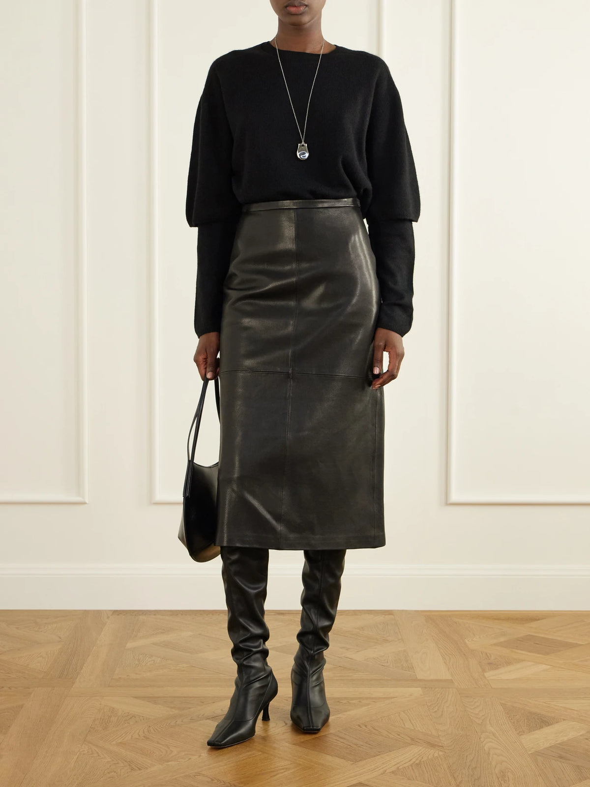 Image of a model wearing Skirts. Product name - Alana Paneled Leather Midi Skirt in Black colour by brand - Nour Hammour