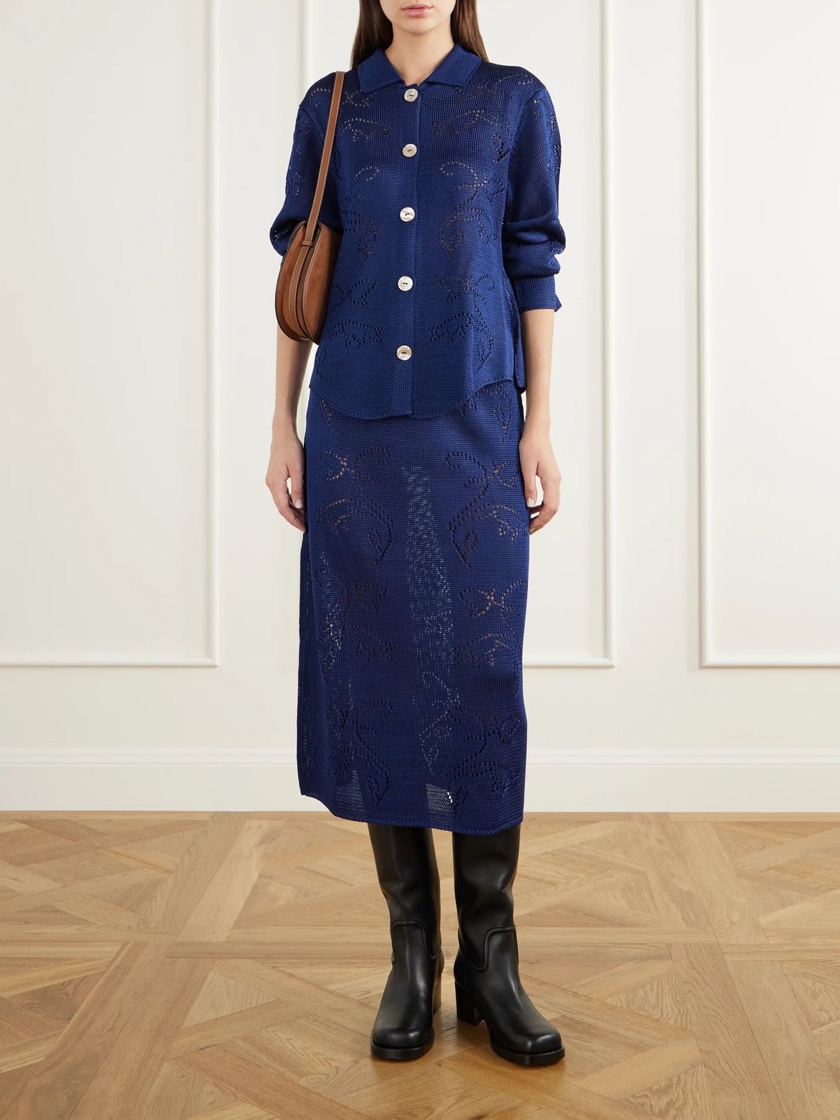 Image of a model wearing Skirts. Product name - Squash Blossom Pointelle-knit Midi Skirt in Navy colour by brand - Calle Del Mar