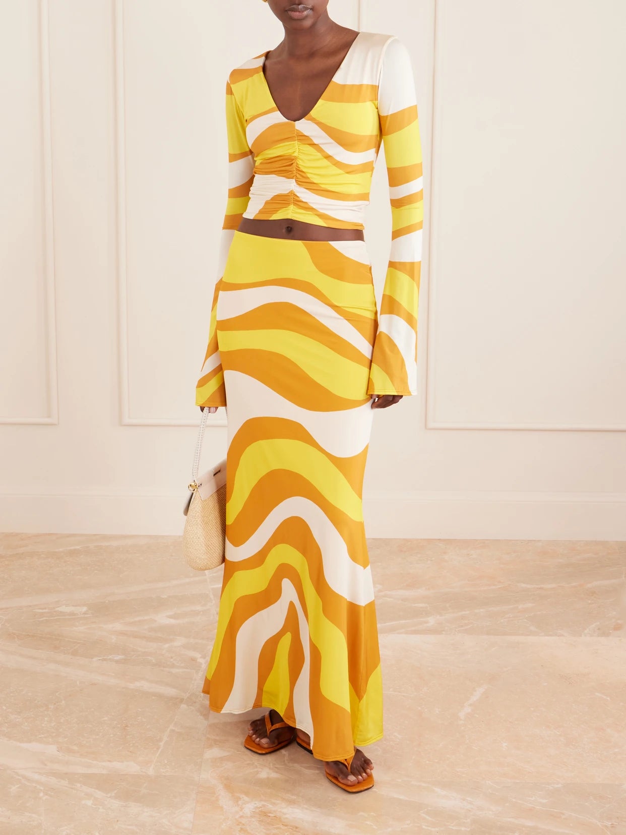 Image of a model wearing Skirts. Product name - Halia Printed Jersey Midi Skirt in Yellow colour by brand - Cala de la Cruz