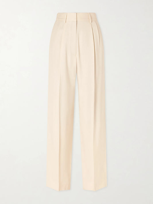 Image of a model wearing Pants. Product name - Danae Pleated Tapered Woven Pants in Beige colour by brand - BLAZÉ Milano