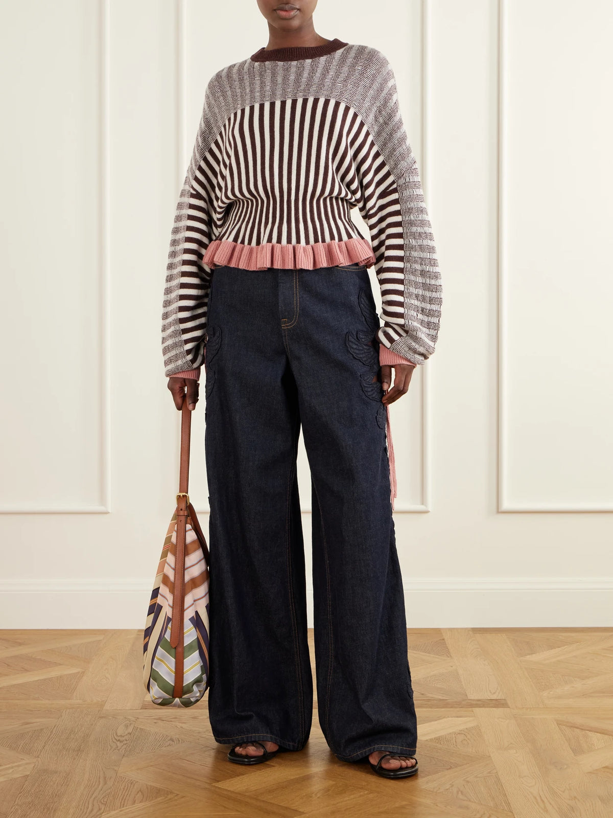Image of a model wearing Outerwear. Product name - Clash Bow-detailed Ruffled Striped Merino Wool And Cotton-blend Sweater in Multi colour by brand - Zimmermann