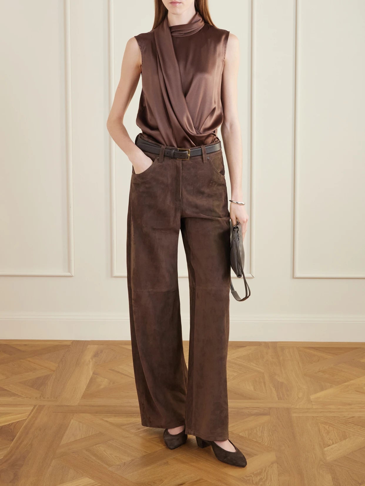 Image of a model wearing Tops. Product name - Wrap-effect Sleeveless Draped Silk-blend Satin Blouse in Dark brown colour by brand - Brunello Cucinelli