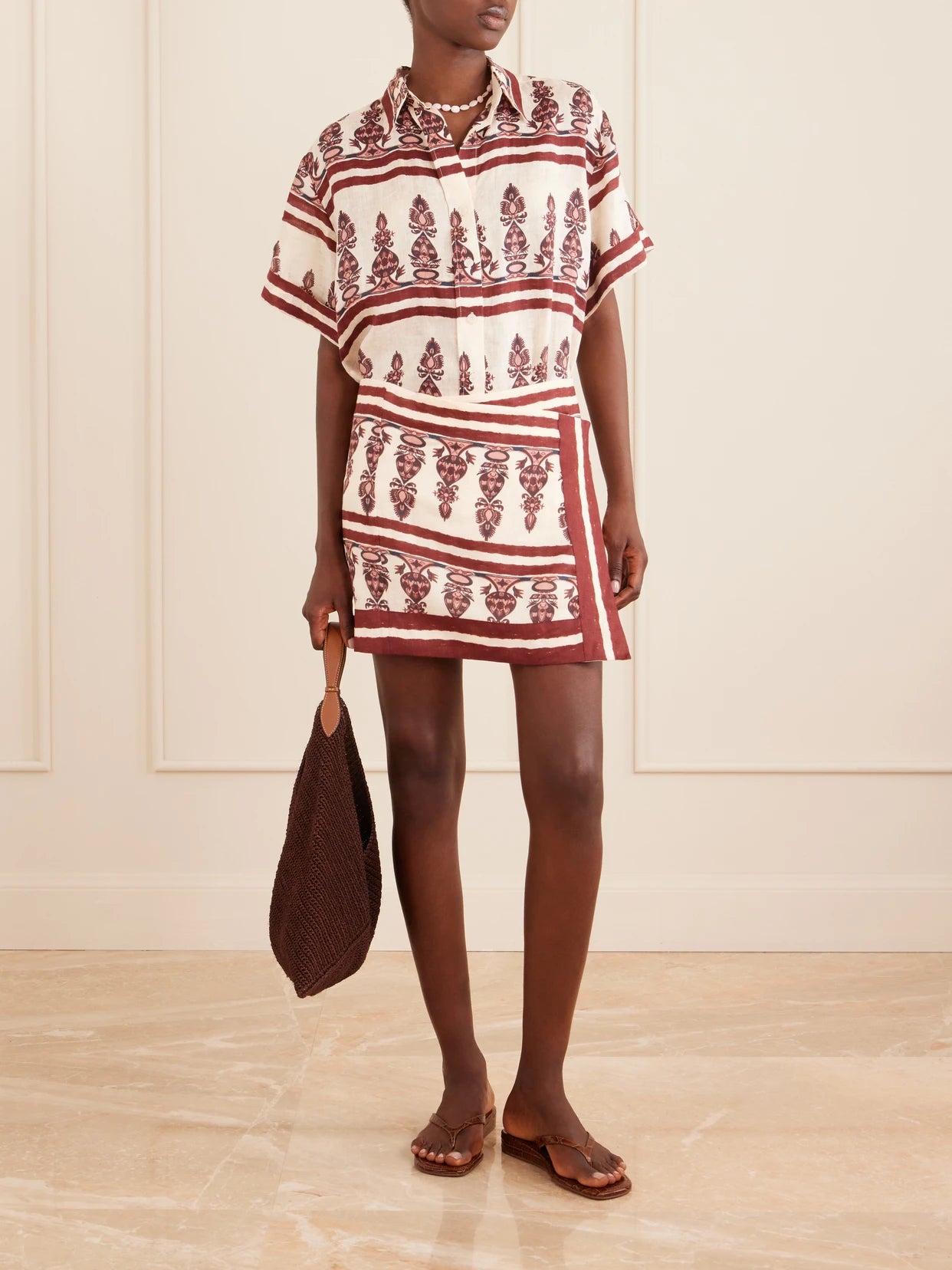 Image of a model wearing Skirts. Product name - Printed Linen Mini Wrap Skirt in Ecru colour by brand - Johanna Ortiz