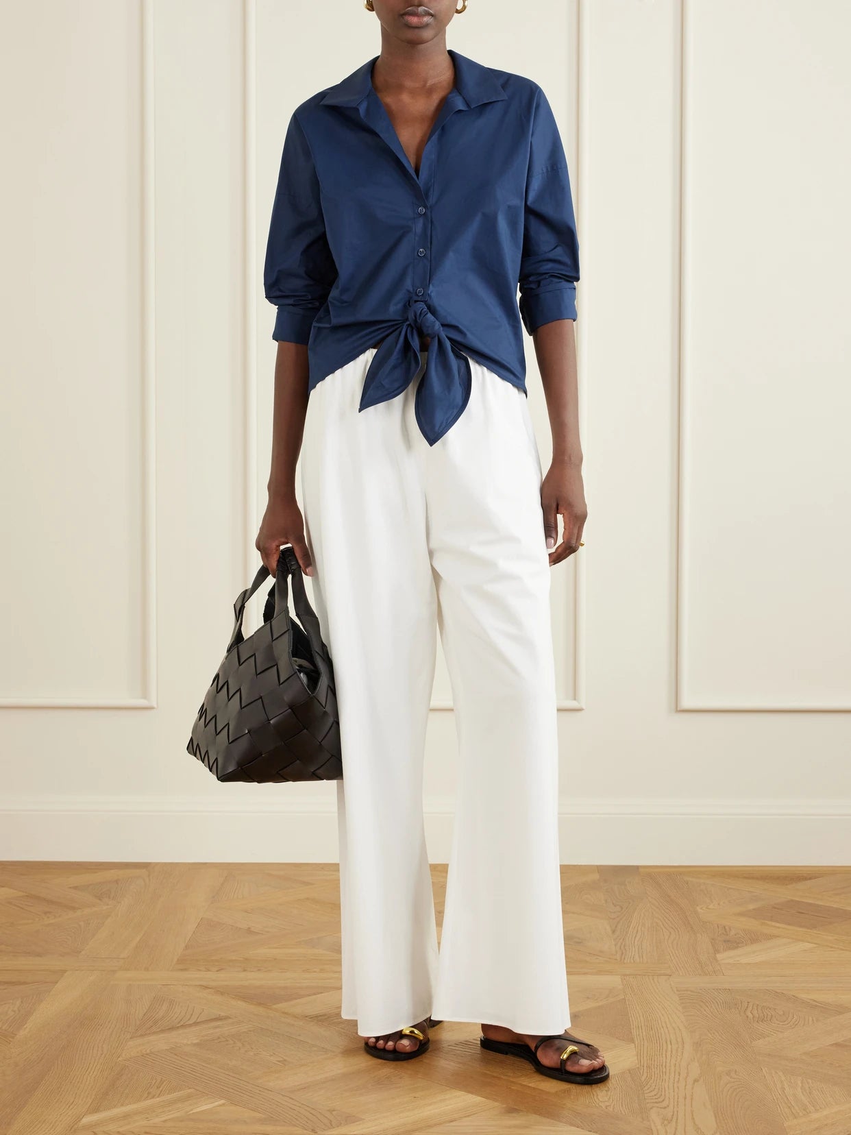 Image of a model wearing Tops. Product name - Dalila Knotted Cotton-poplin Blouse in Navy colour by brand - Andres Otalora