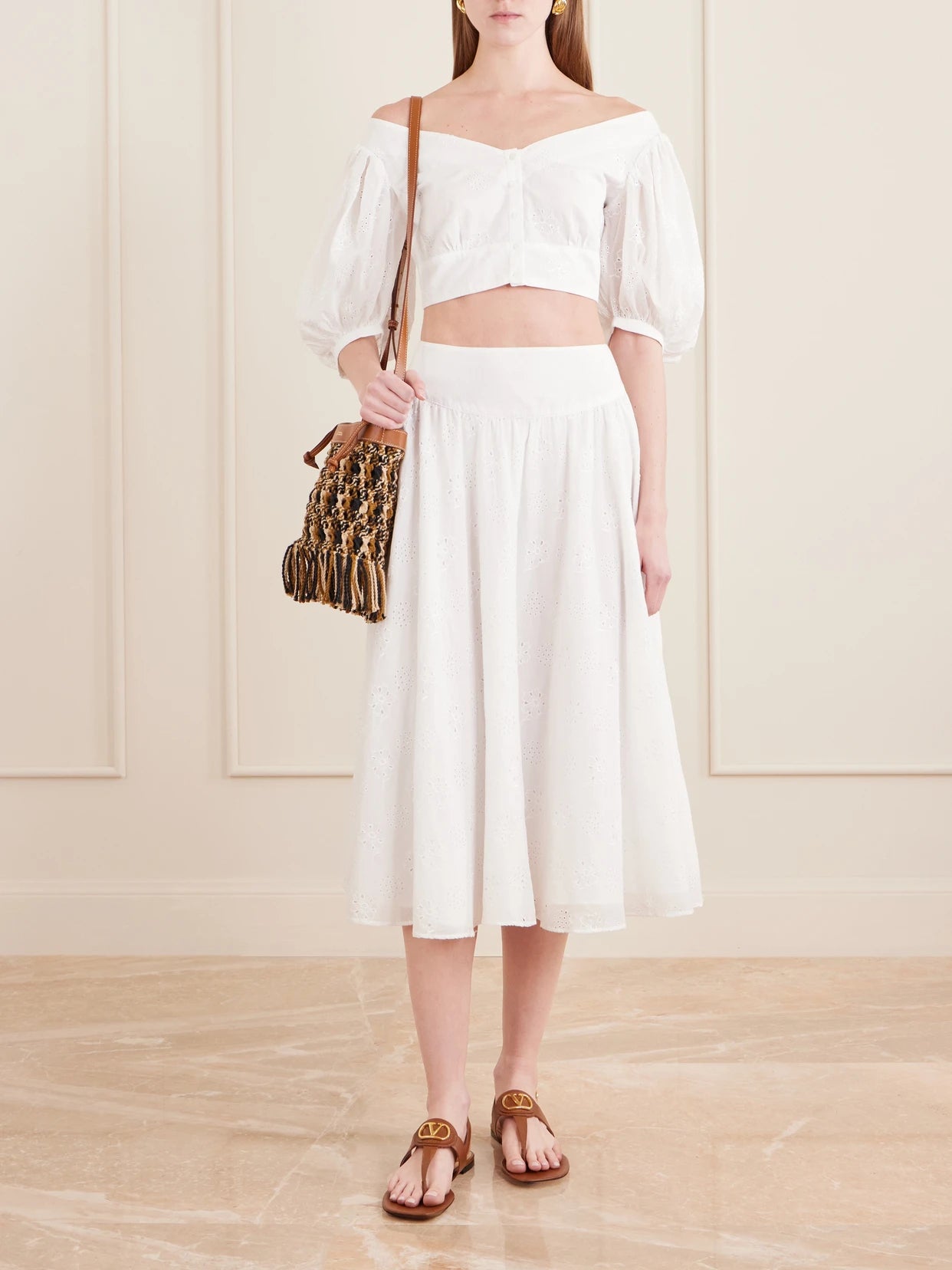 Image of a model wearing Skirts. Product name - Pamela Pleated Broderie Anglaise Cotton Midi Skirt in Off-white colour by brand - Thierry Colson