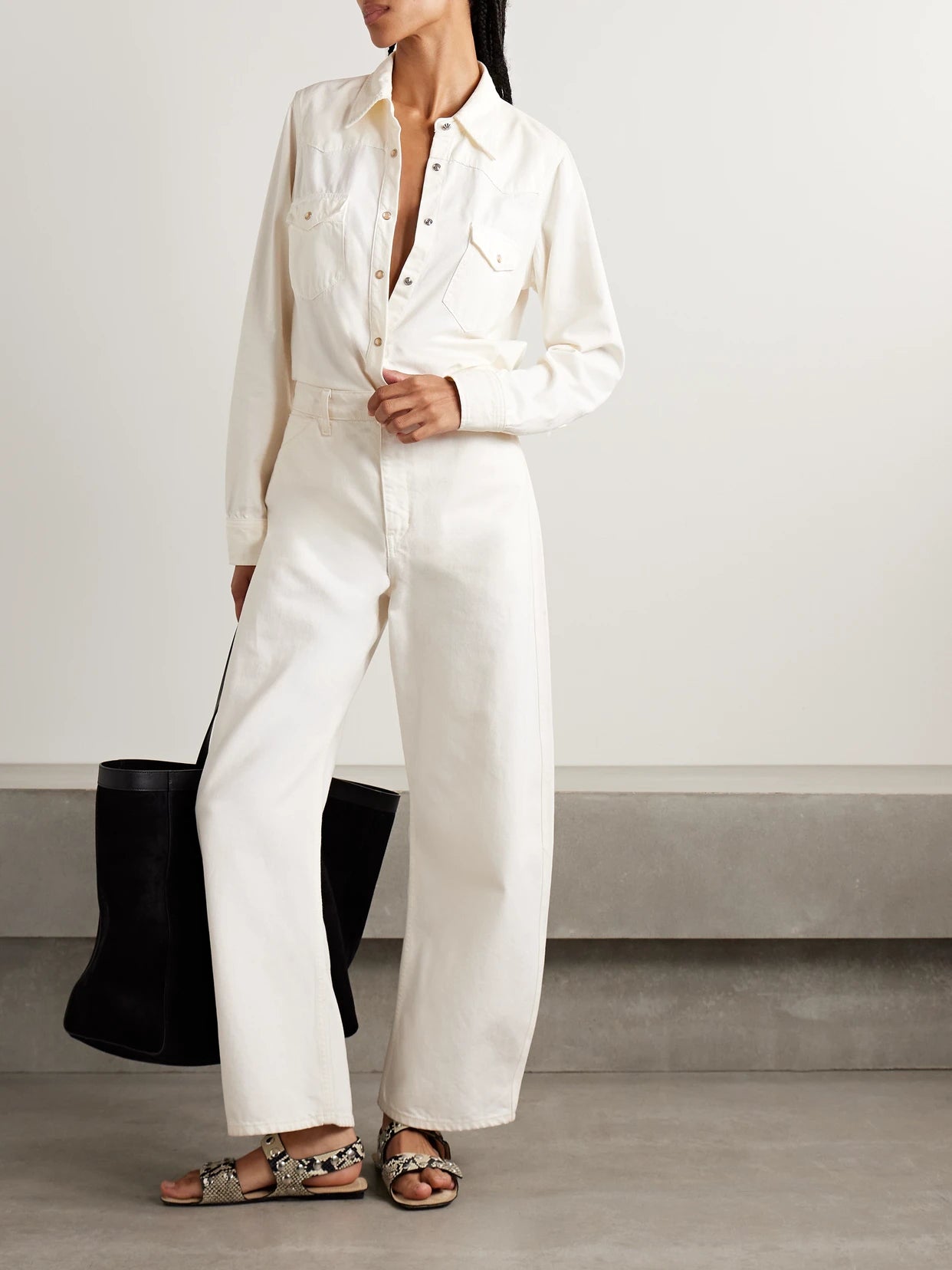 Image of a model wearing Tops. Product name - Travis Denim Shirt in Cream colour by brand - Nili Lotan