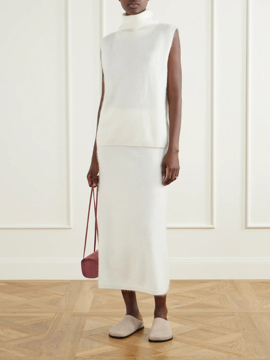 Image of a model wearing Outerwear. Product name - Aisla Ribbed Brushed Cashmere Turtleneck Sweater Vest in Cream colour by brand - LISA YANG