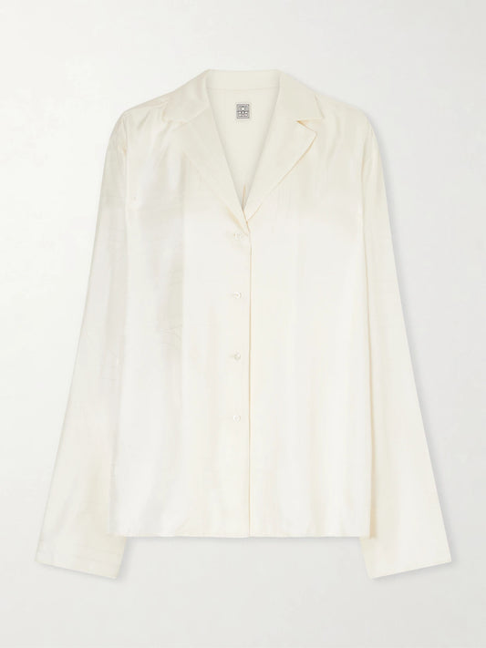 Image of a model wearing Tops. Product name - Embroidered Silk-satin Shirt in Cream colour by brand - TOTEME