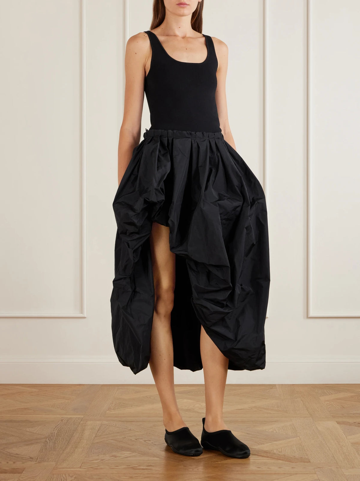 Image of a model wearing Skirts. Product name - Asymmetric Shell Midi Skirt in Black colour by brand - Jil Sander
