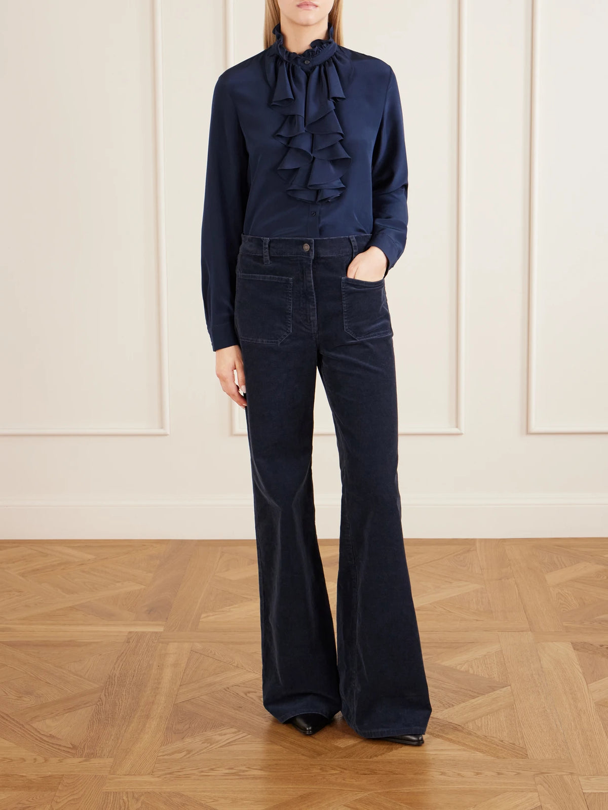 Image of a model wearing Tops. Product name - Lily Ruffled Silk-satin Blouse in Navy colour by brand - Nili Lotan