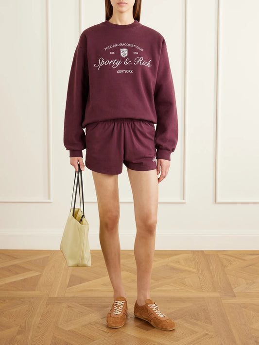Image of Sleepwear & Loungewear. Product name - Syracuse Logo-embroidered Cotton-fleece Shorts in Burgundy colour by brand - Sporty & Rich