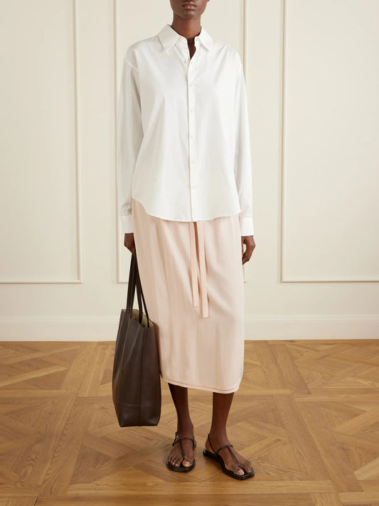 Image of a model wearing Skirts. Product name - Silk Midi Skirt in Baby pink colour by brand - TOTEME