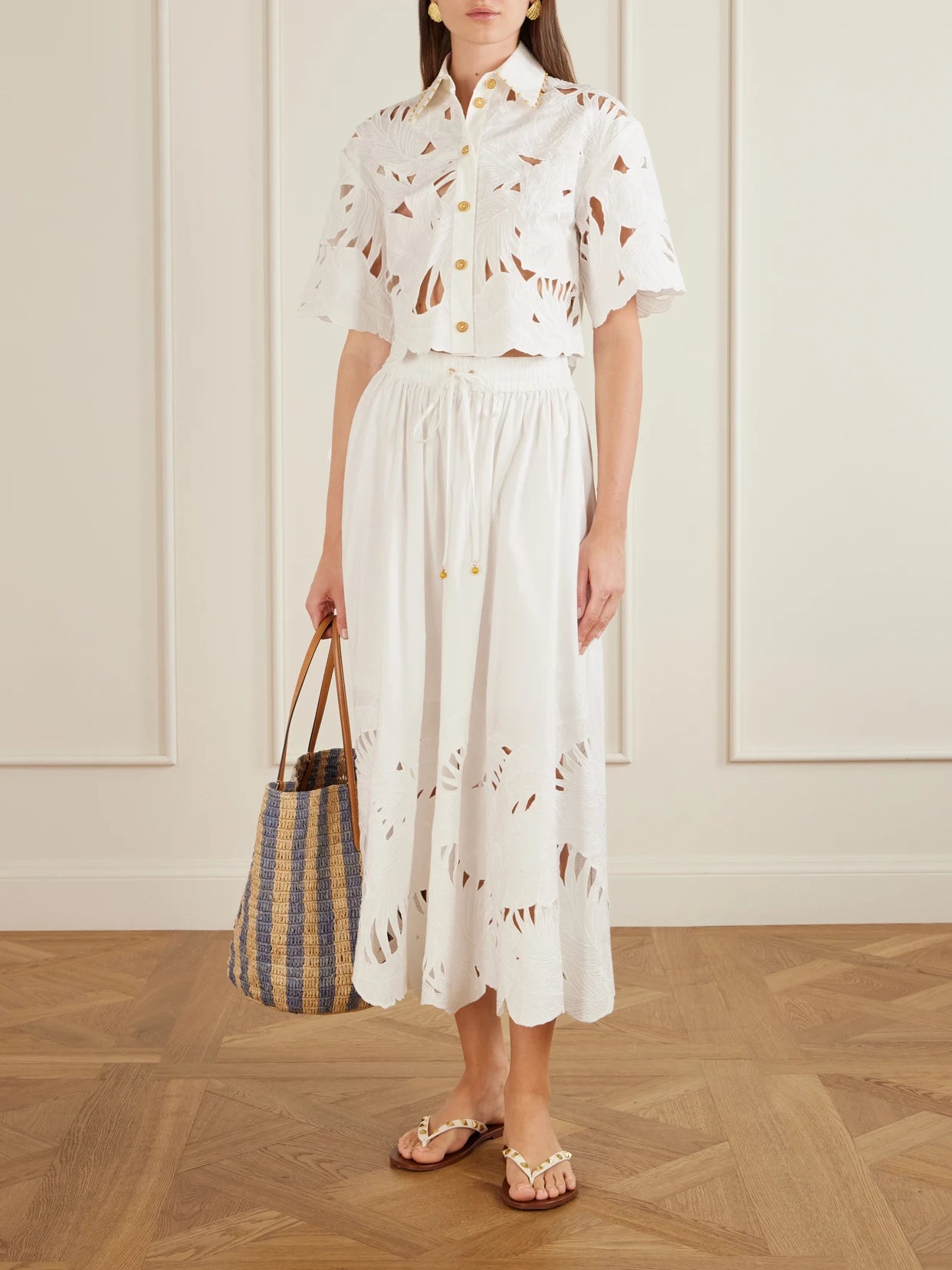Image of a model wearing Skirts. Product name - Mahon Embroidered Cotton Midi Skirt in Ivory colour by brand - Zimmermann