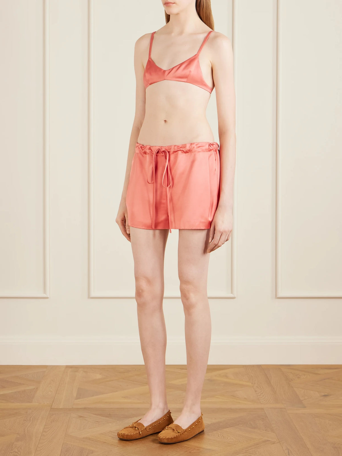 Image of a model wearing Tops. Product name - Talita Satin Bralette in Pink colour by brand - KHAITE