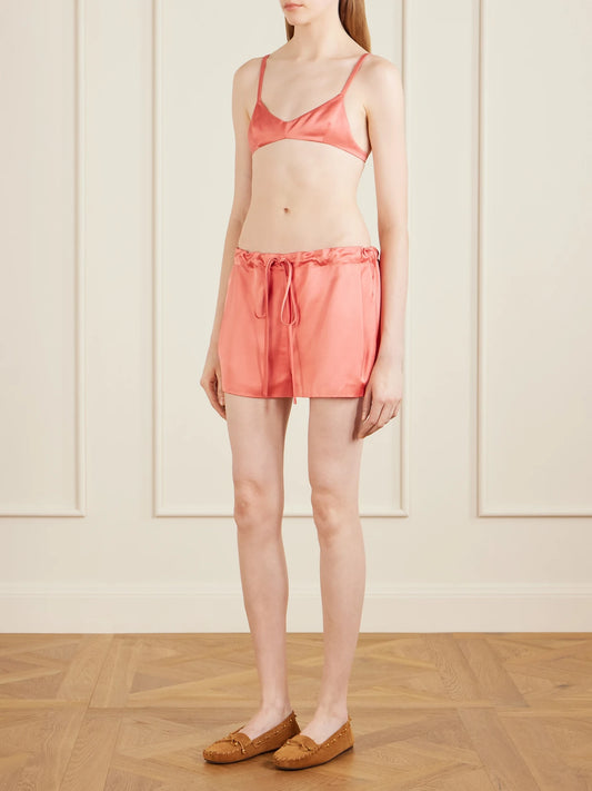 Image of a model wearing Tops. Product name - Talita Satin Bralette in Pink colour by brand - KHAITE