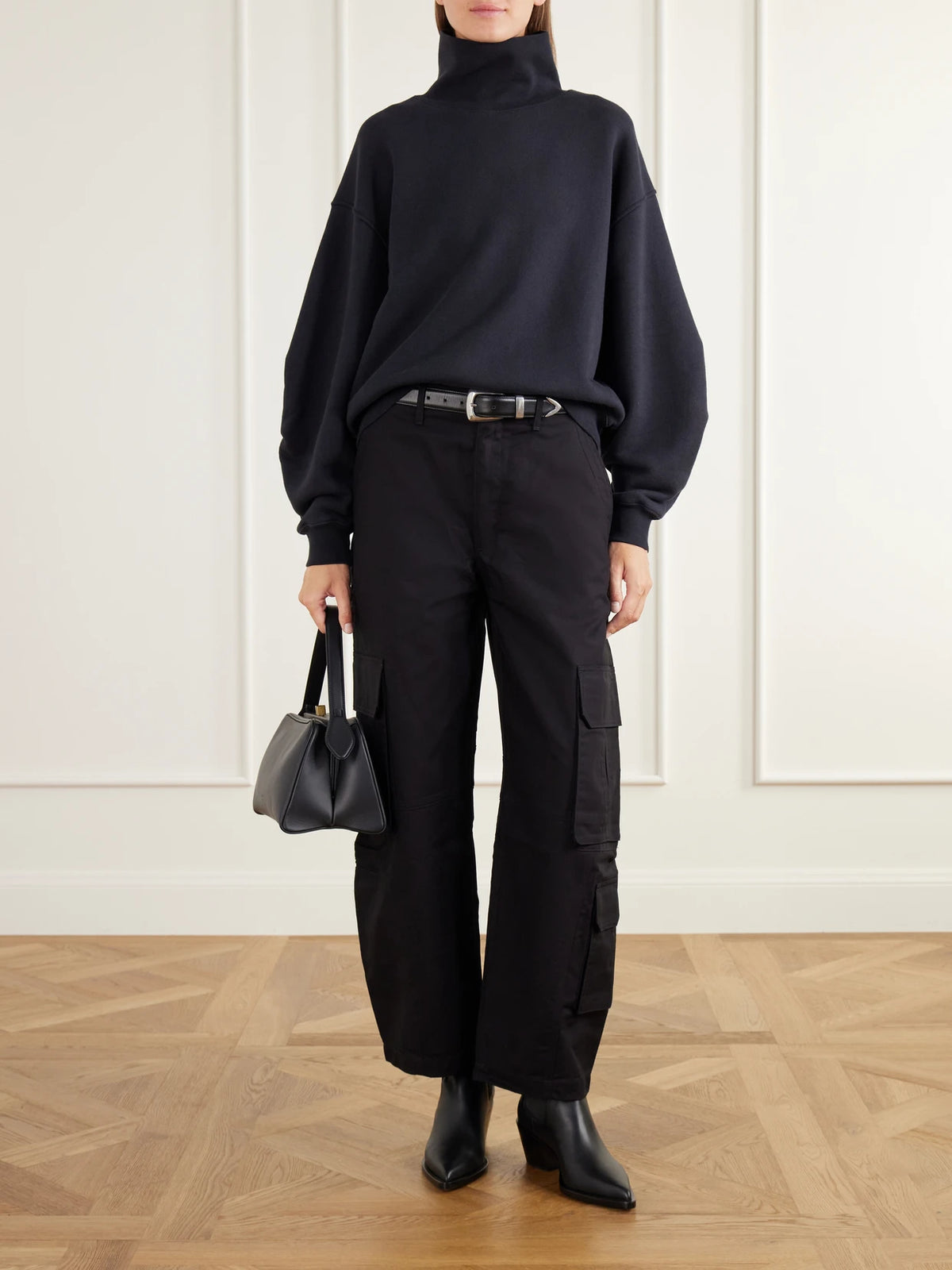 Image of a model wearing Tops. Product name - Jenning Cotton-fleece Turtleneck Sweatshirt in Black colour by brand - AGOLDE