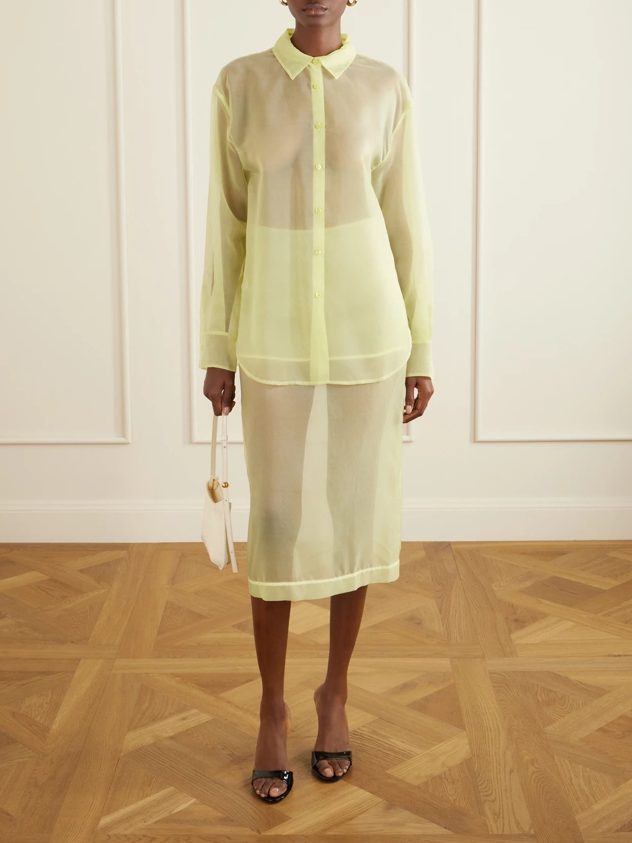 Image of a model wearing Skirts. Product name - Peri Sheer Silk-blend Midi Skirt in Pastel yellow colour by brand - The Frankie Shop
