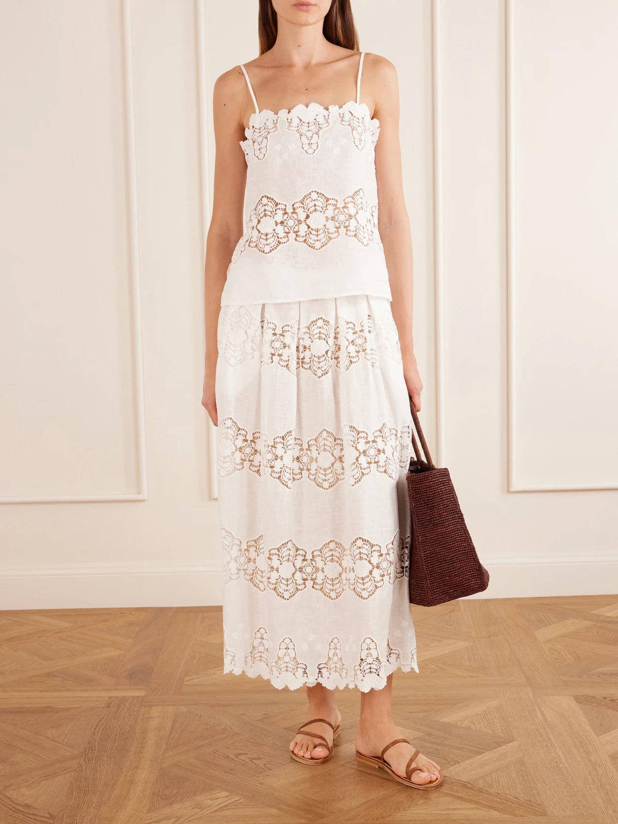 Image of a model wearing Skirts. Product name - Carissa Embroidered Cotton And Linen-blend Midi Skirt in Ivory colour by brand - Miguelina