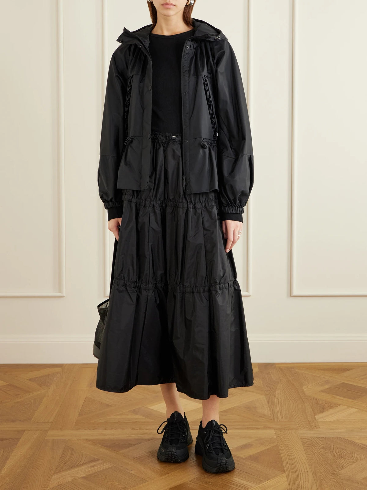 Image of a model wearing Skirts. Product name - Tiered Shell Midi Skirt in Black colour by brand - Moncler