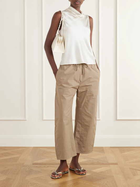 Image of a model wearing Tops. Product name - Barb Draped Satin Blouse in Cream, Dark green colour by brand - LESET