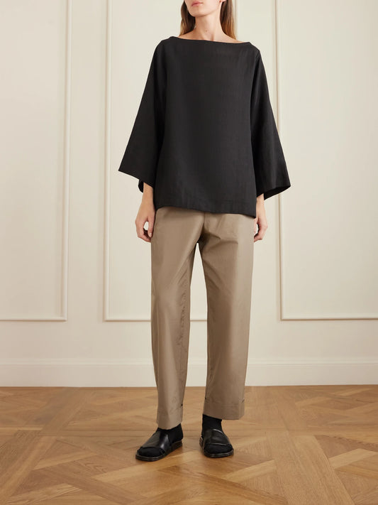 Image of a model wearing Tops. Product name - Junia Oversized Linen Blouse in Black colour by brand - The Row