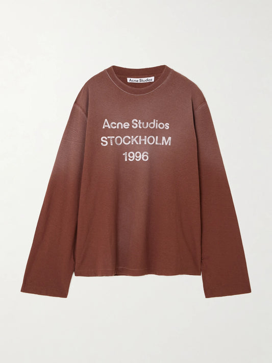 Image of a model wearing Tops. Product name - Oversized Printed Organic Cotton And Hemp-blend Jersey T-shirt in Brown colour by brand - Acne Studios