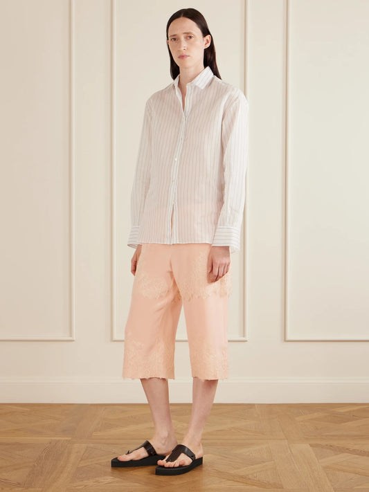 Image of a model wearing Shorts. Product name - Auden Lace-trimmed Silk-satin Shorts in Pastel pink colour by brand - AFLALO