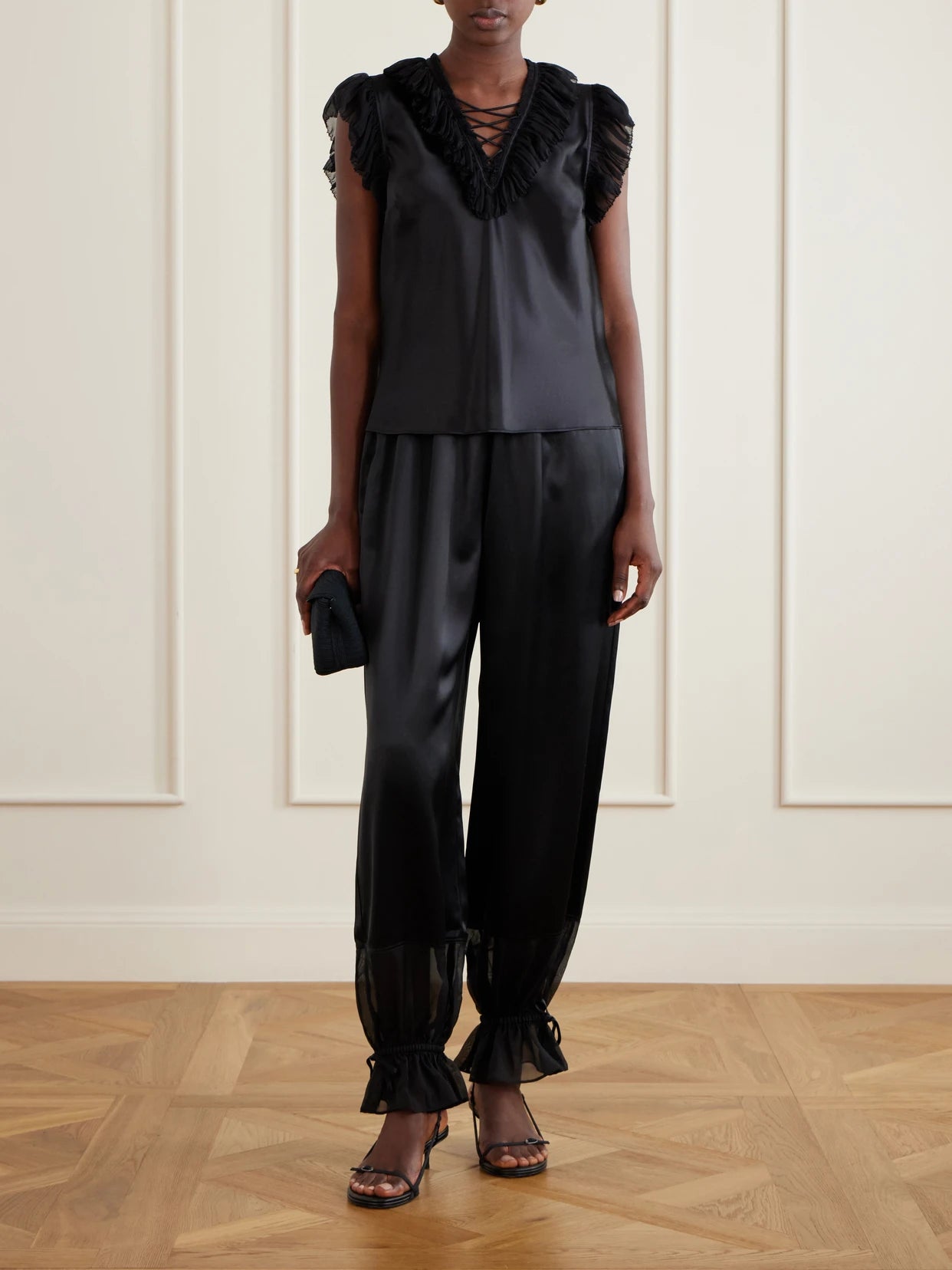 Image of a model wearing Pants. Product name - Camile Cinched Ruffled Silk Balloon Pants in Black colour by brand - Ulla Johnson
