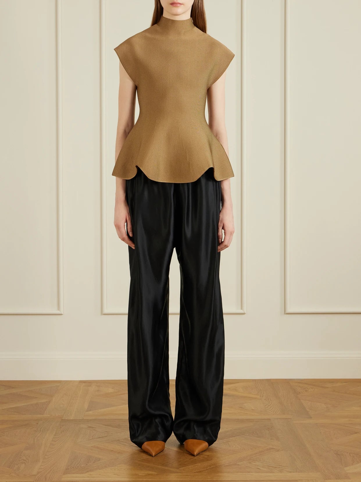 Image of a model wearing Pants. Product name - Rohen Satin Pants in Black colour by brand - KHAITE