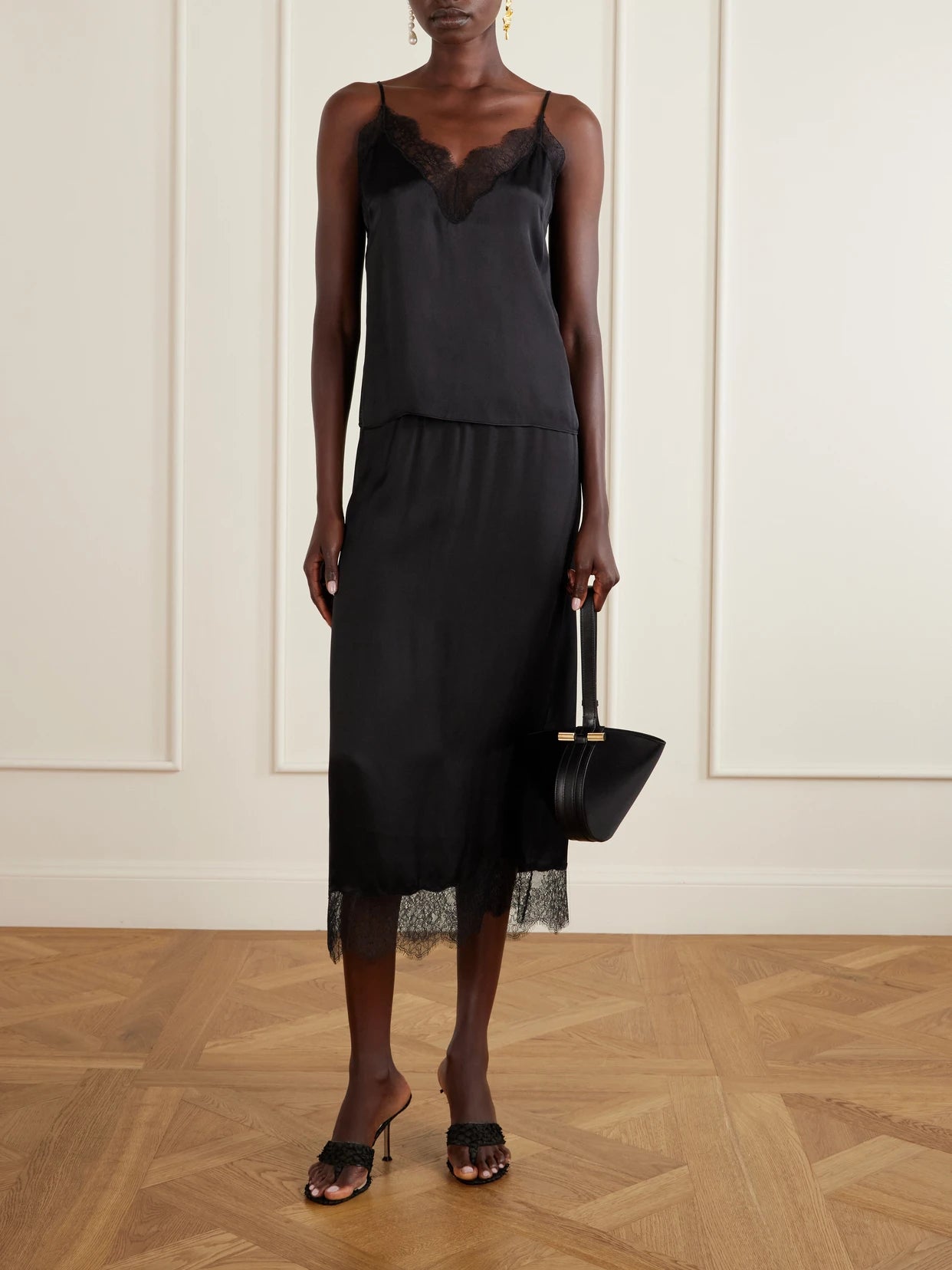 Image of a model wearing Tops. Product name - Mael Lace-trimmed Silk-blend Satin Top in Black colour by brand - Anine Bing