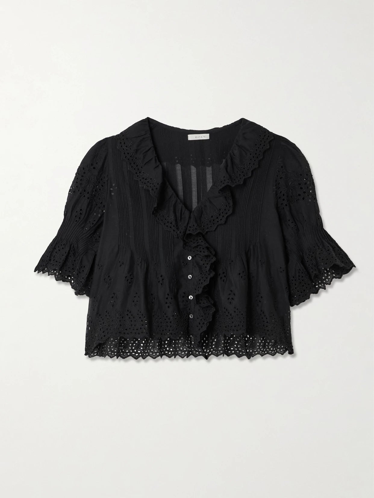 Image of a model wearing Tops. Product name - Henri Cropped Ruffled Pintucked Broderie Anglaise Cotton Top in Black colour by brand - DÔEN