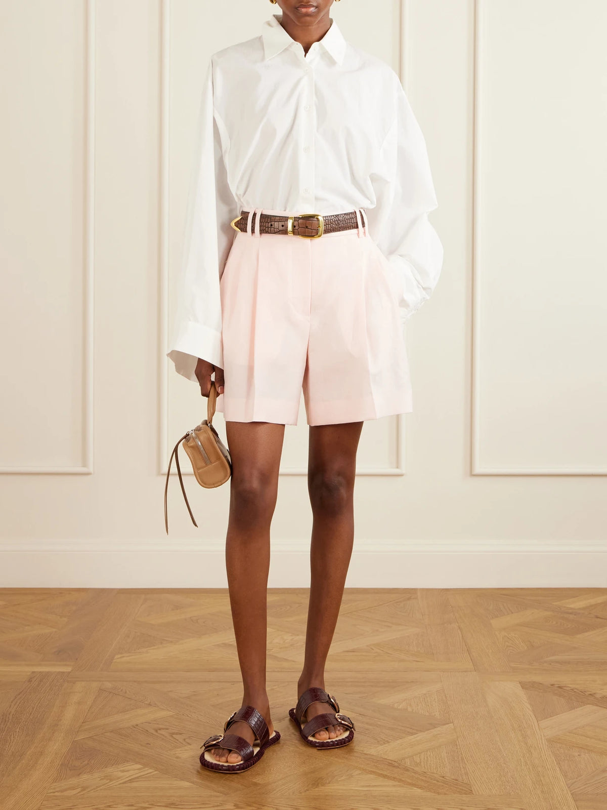 Image of a model wearing Shorts. Product name - Pleated Linen Shorts in Pastel pink colour by brand - Another Tomorrow