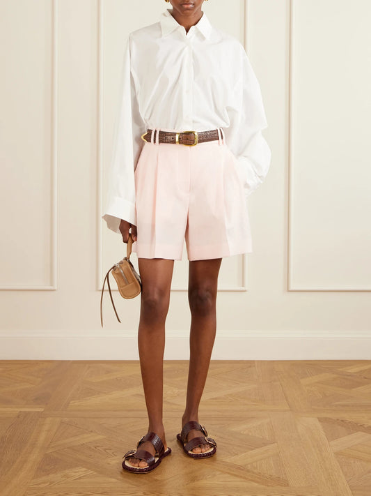 Image of a model wearing Shorts. Product name - Pleated Linen Shorts in Pastel pink colour by brand - Another Tomorrow