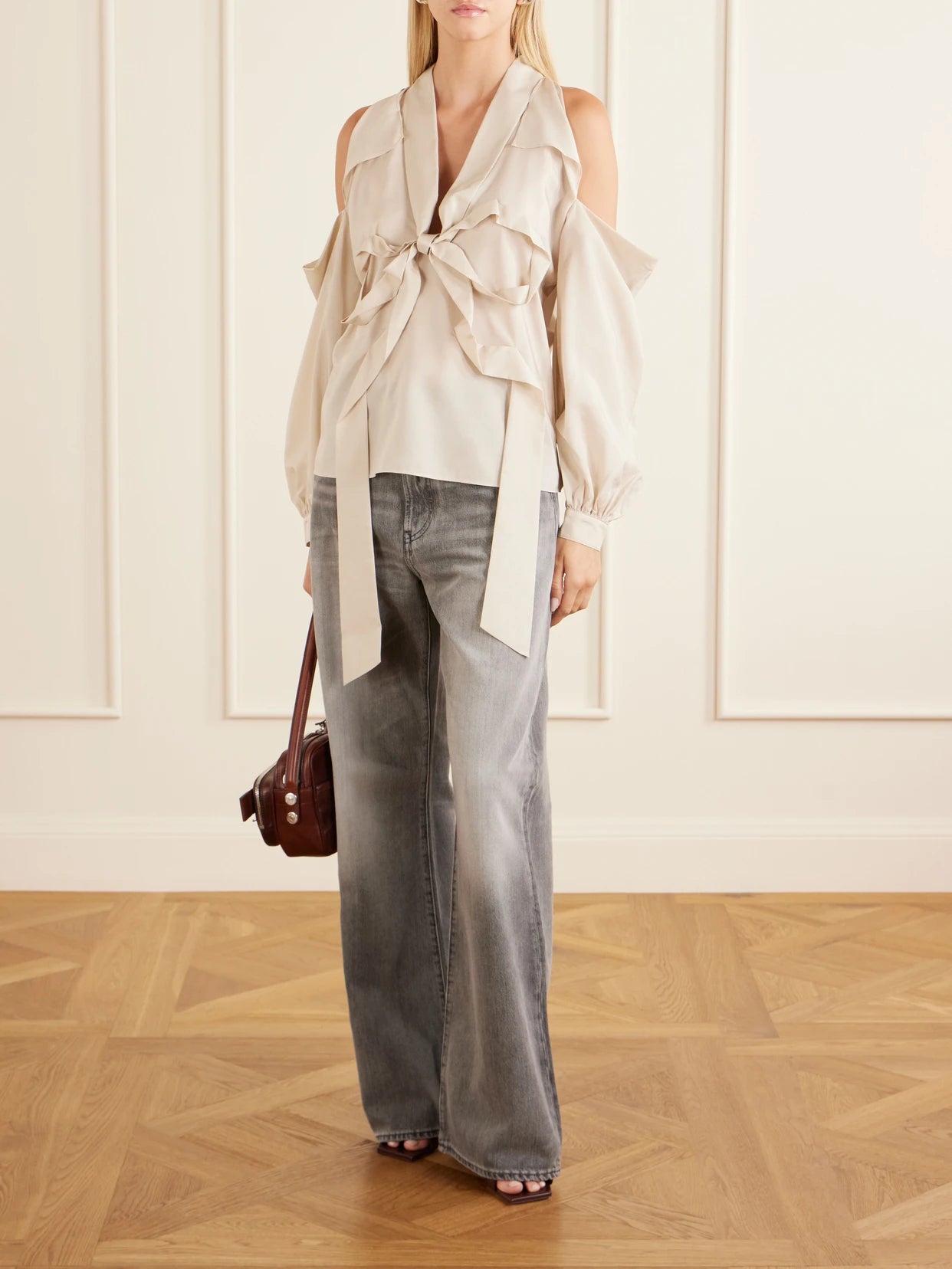 Image of a model wearing Tops. Product name - Bow-embellished Cut-out Lyocell Blouse in Beige colour by brand - Acne Studios