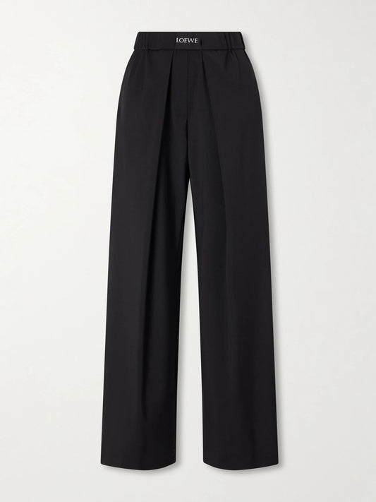 Image of a model wearing Pants. Product name - Pleated Wool Mid-rise Straight-leg Pants in Black colour by brand - LOEWE