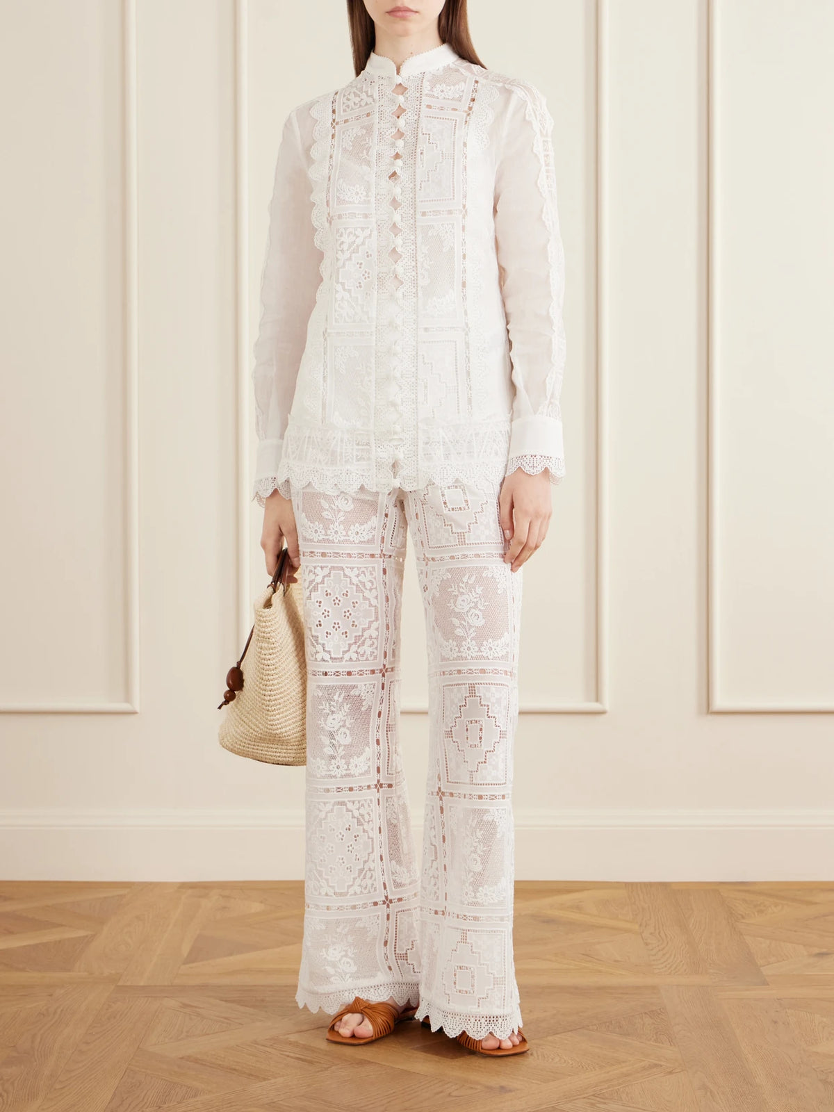 Image of a model wearing Pants. Product name - Aster Embroidered Mesh Flared Pants in Ivory colour by brand - Zimmermann