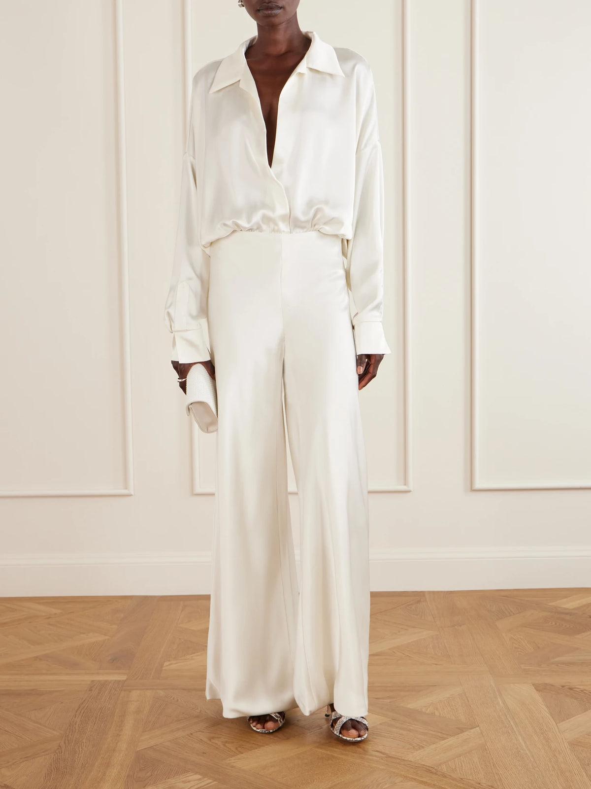 Image of a model wearing Pants. Product name - Satin High-rise Wide-leg Pants in White colour by brand - Norma Kamali
