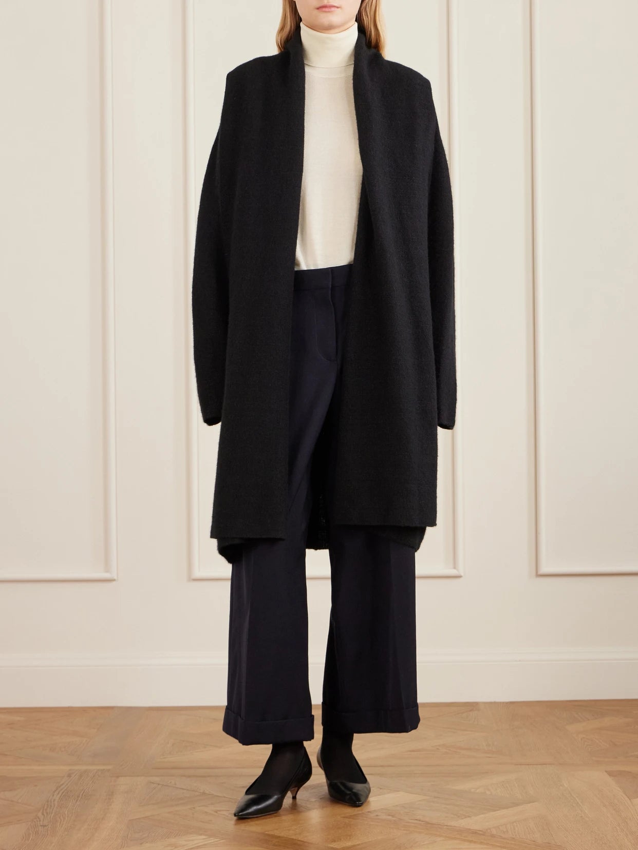 Image of a model wearing Outerwear. Product name - Nabari Cashmere Turtleneck Sweater in Ivory colour by brand - The Row
