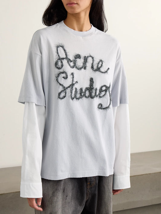 Image of a model wearing Tops. Product name - Layered Embroidered Cotton-jersey And Poplin T-shirt in Light blue colour by brand - Acne Studios