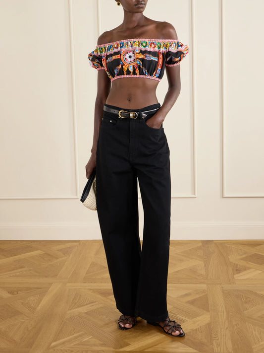 Image of a model wearing Tops. Product name - Carretto Off-the-shoulder Cropped Printed Cotton-poplin Top in Black colour by brand - Dolce & Gabbana