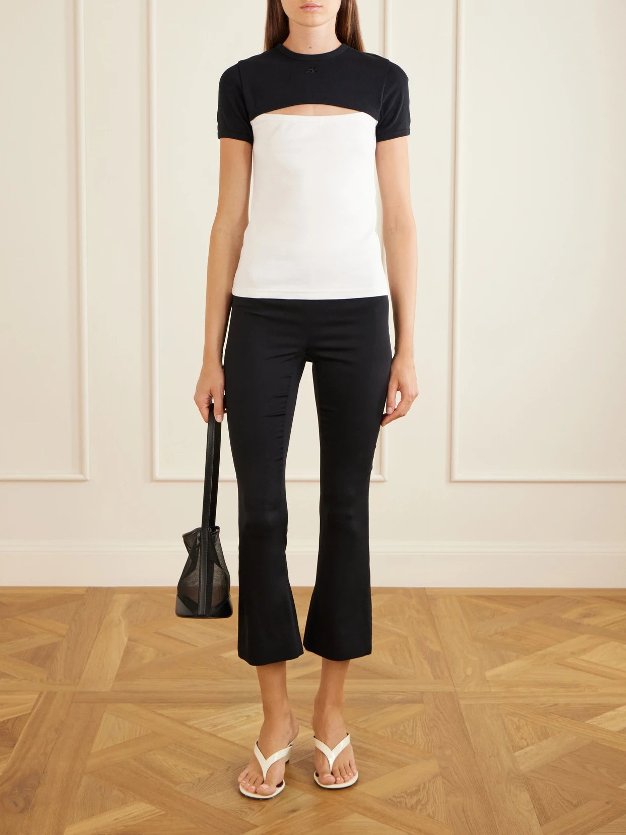 Image of a model wearing Tops. Product name - Slash Contrast Logo-embroidered Cut-out Cotton T-shirt in White colour by brand - COURREGES